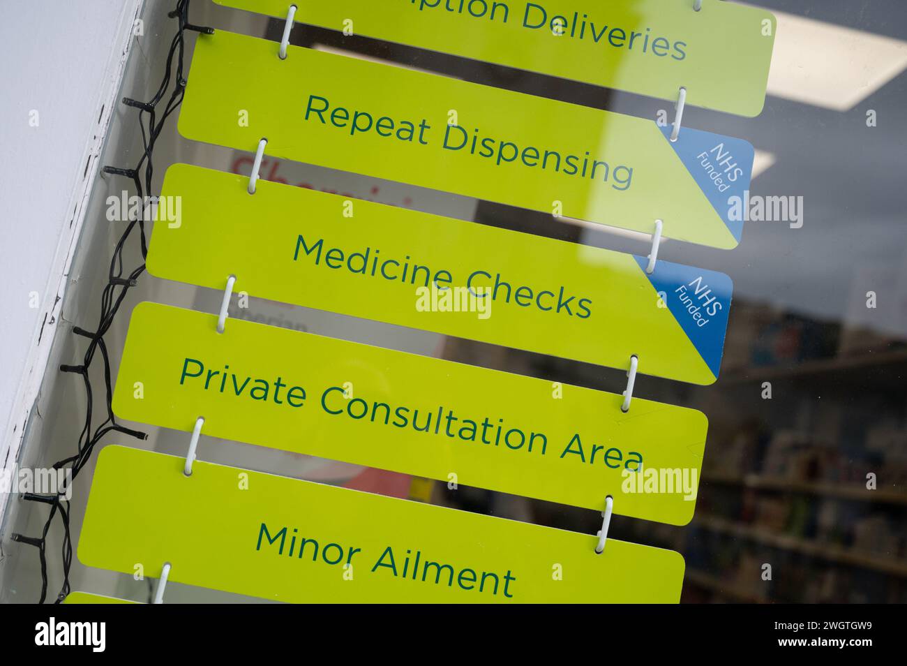 Segni in un farmacista di farmacia negozio finestra che offre consulenze sanitarie private e trattamenti da farmacista. Foto Stock