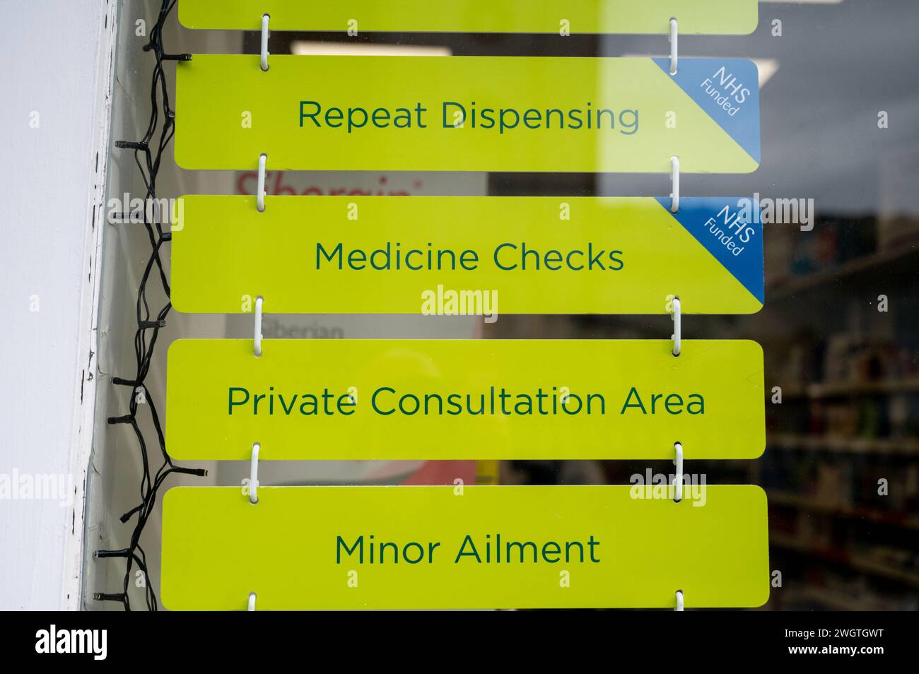 Segni in un farmacista di farmacia negozio finestra che offre consulenze sanitarie private e trattamenti da farmacista. Foto Stock