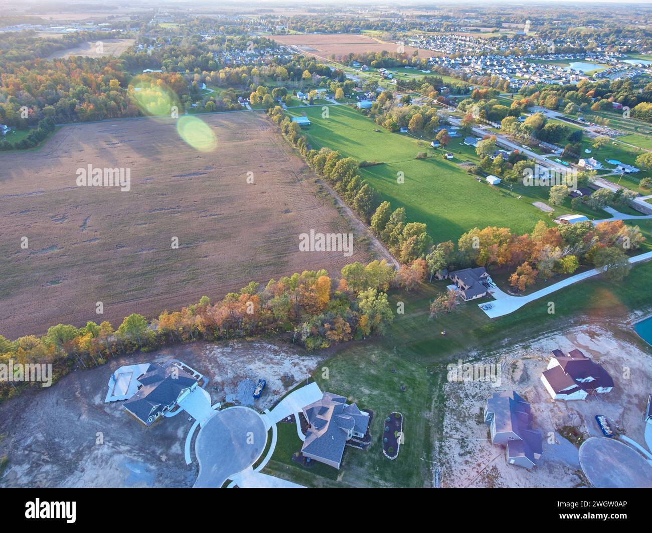 Vista aerea dell'espansione suburbana in terreni agricoli all'ora d'oro Foto Stock