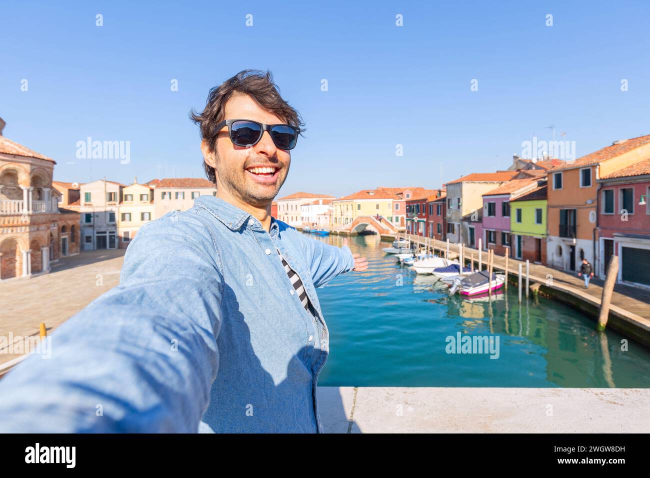 Un viaggiatore felice che fa un selfie sulla famosa isola di Murano vicino a Venezia. Concetto di viaggio e vacanza in Italia Foto Stock