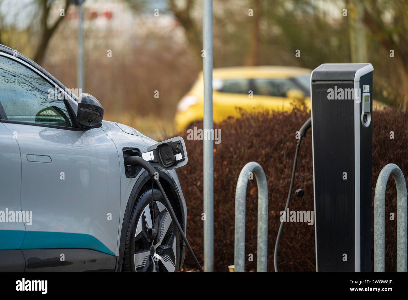 Un auto elettrica in corrispondenza di una stazione di carica Foto Stock