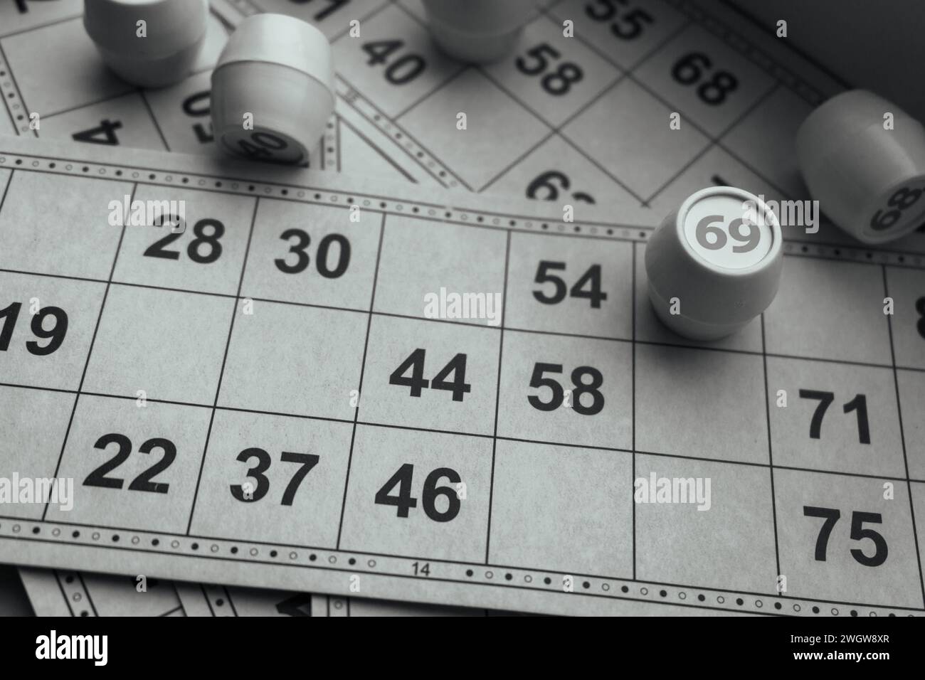 Partita lotto, bianco e nero. Stile di vita nostalgico. Giochi da tavolo. Giochi retrò. Bingo Time, monocromatico. Barili con numeri e carte di carta per il bingo. Foto Stock