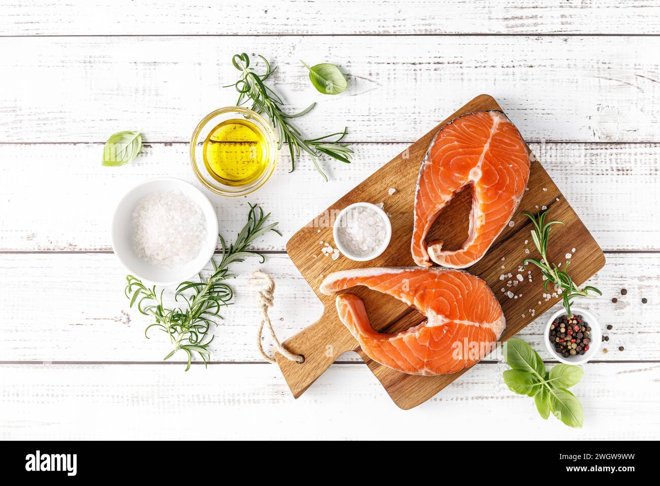 Bistecche di salmone crude fresche su tavola con ingredienti per cucinare, vista dall'alto Foto Stock