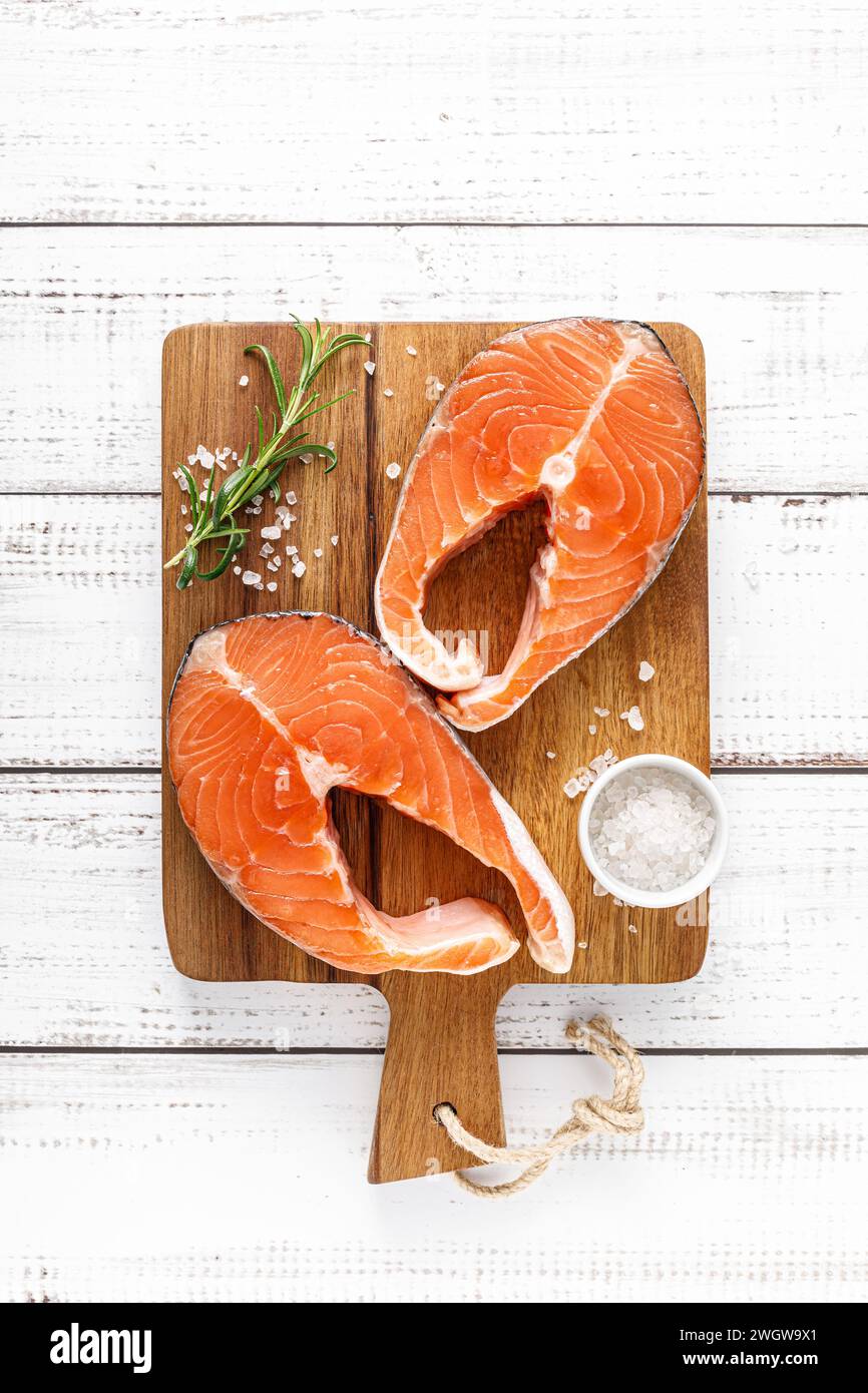 Bistecche di salmone crude fresche su tavola con ingredienti per cucinare, vista dall'alto Foto Stock