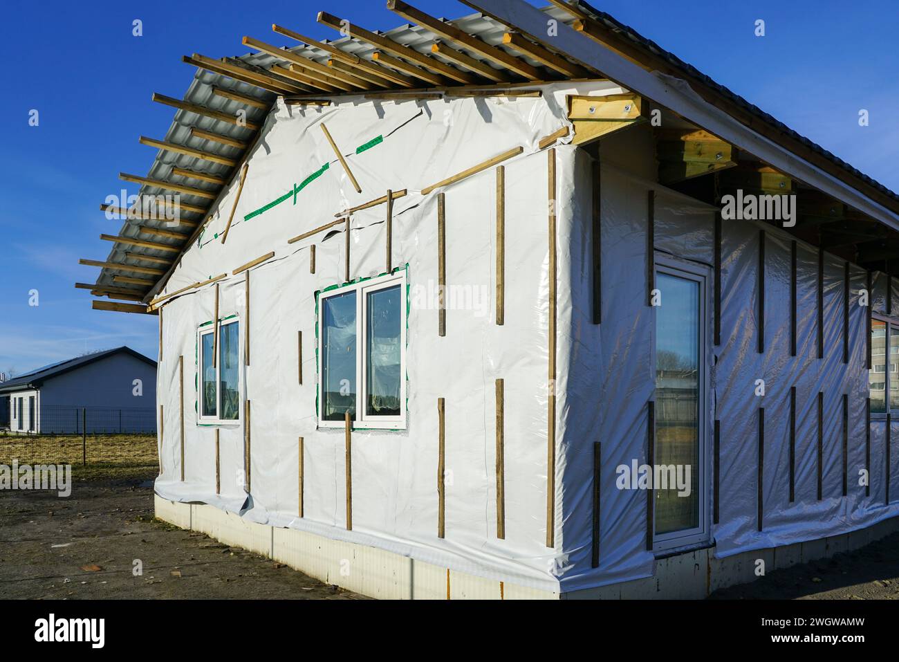 Moderna casa residenziale a un piano senza rifiniture con struttura in legno prima della finitura della facciata Foto Stock