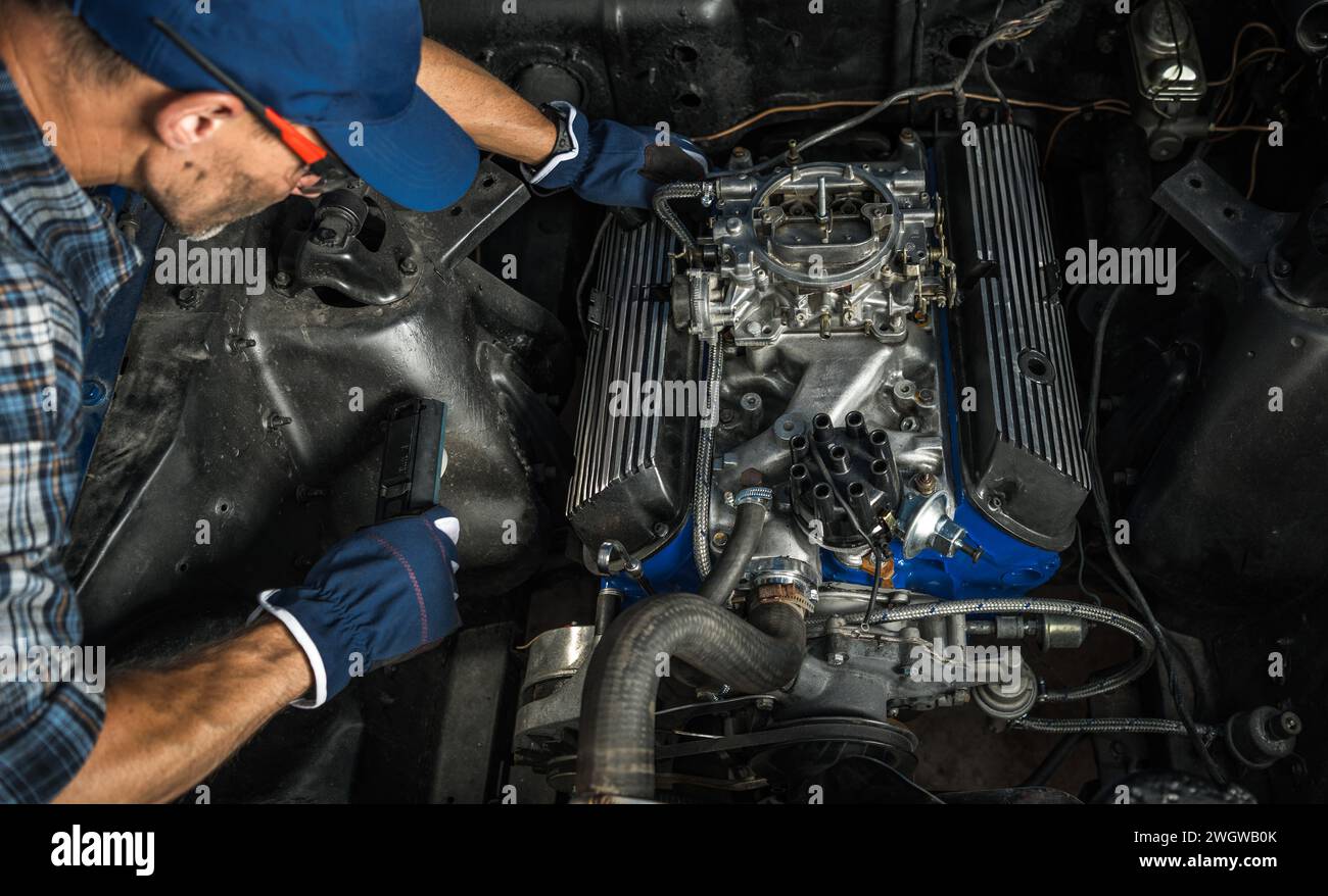 Uomo di 40 anni che ripara il suo motore V8 Classic Muscle Combustion Foto Stock