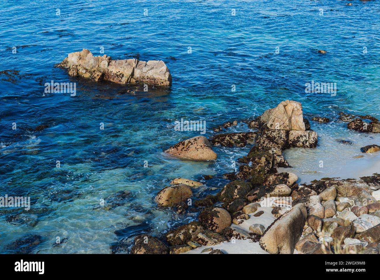 affacciato sulla spiaggia rocciosa con oceano blu Foto Stock