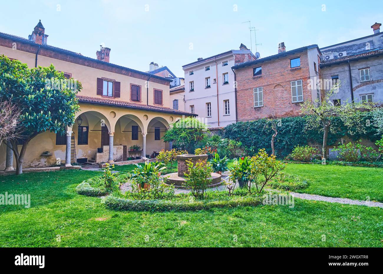 Il bel giardino verde nel cortile della basilica medievale di Sant'Antonino, Piacenza, Italia Foto Stock