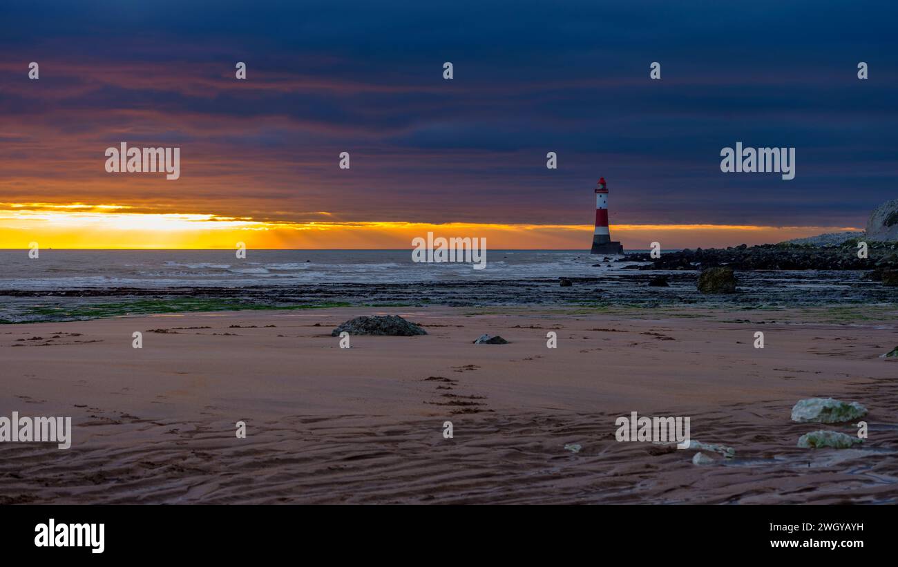 Eastbourne, Regno Unito - 3 febbraio 2023: Tramonto sul faro di Beachy Head attraverso Falling Sands, East Sussex, Regno Unito Foto Stock