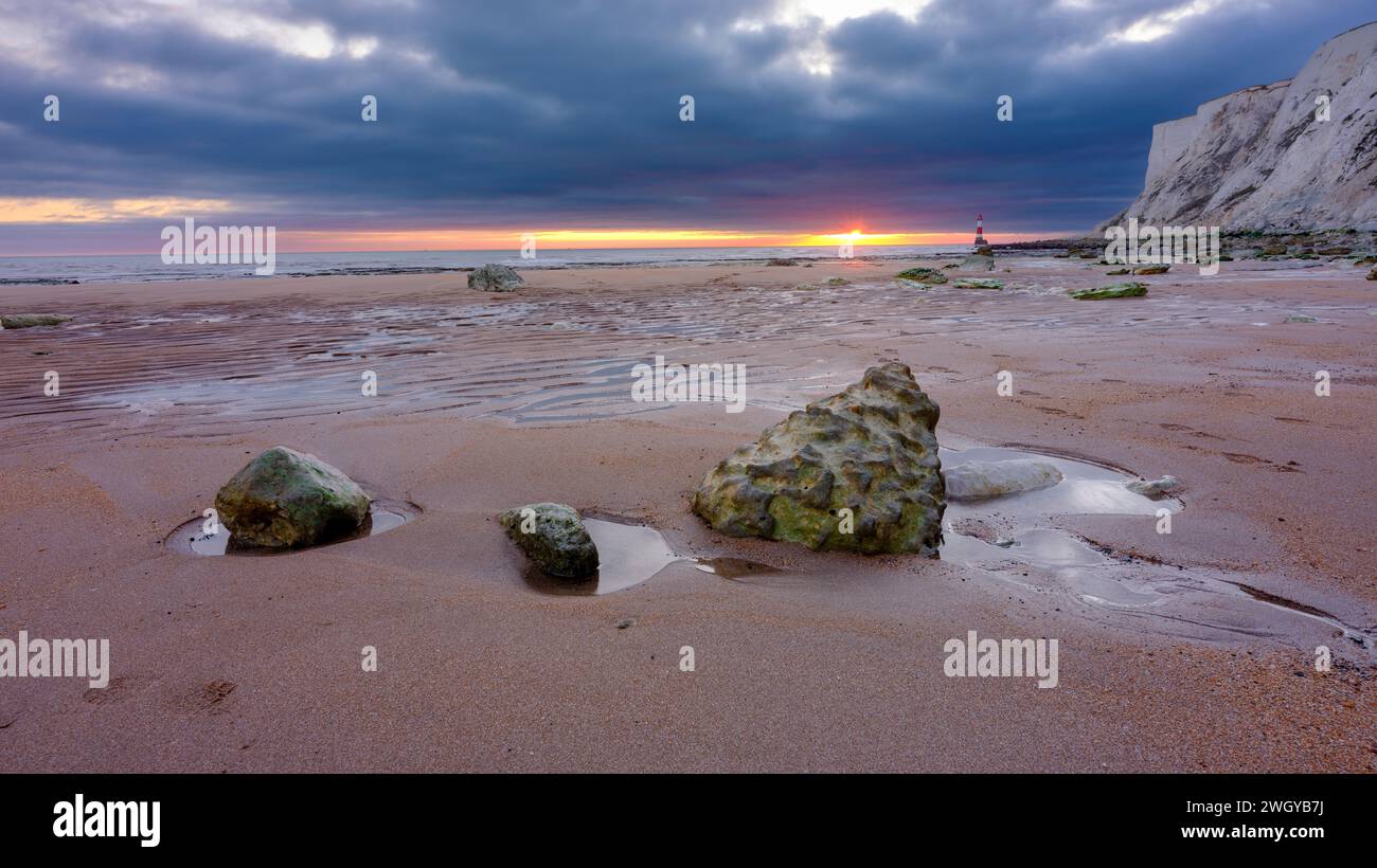 Eastbourne, Regno Unito - 3 febbraio 2023: Tramonto sul faro di Beachy Head attraverso Falling Sands, East Sussex, Regno Unito Foto Stock