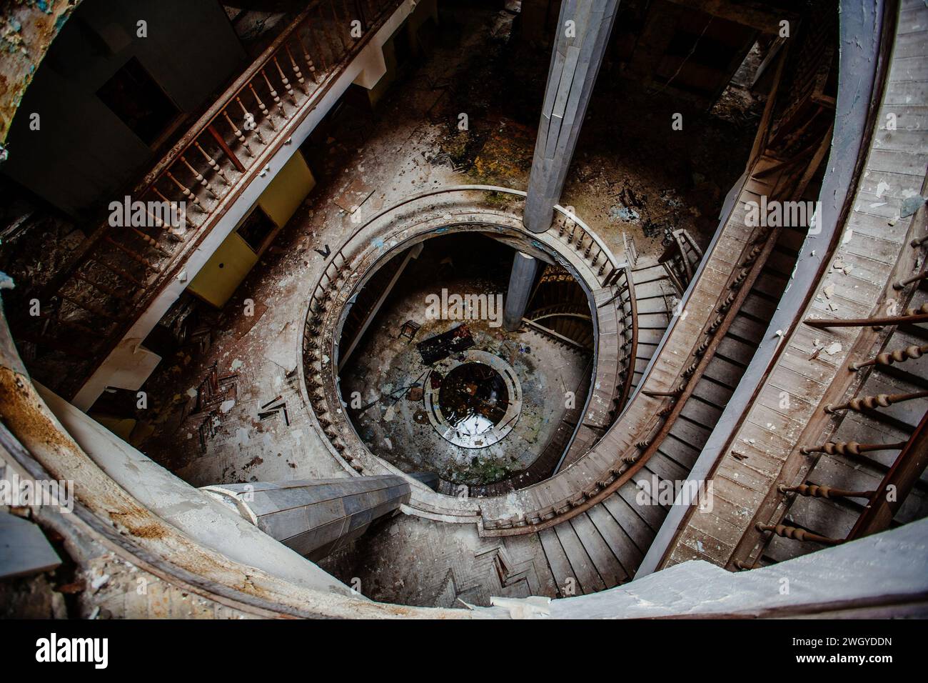 Vista dall'alto di una vecchia scala a chiocciola decorata in stile vintage in un palazzo abbandonato. Foto Stock