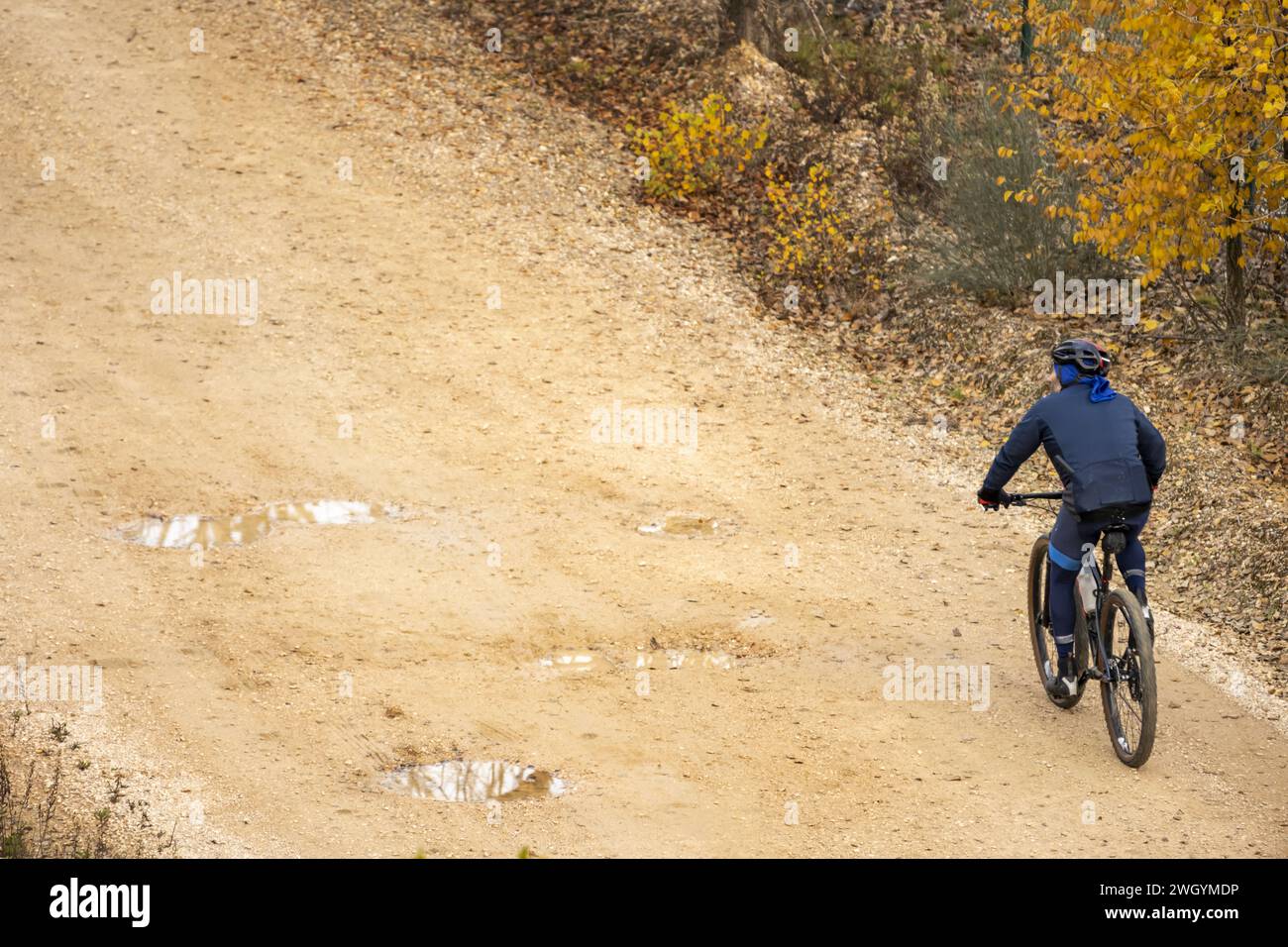 Un ciclista su una pista sterrata con acqua Foto Stock