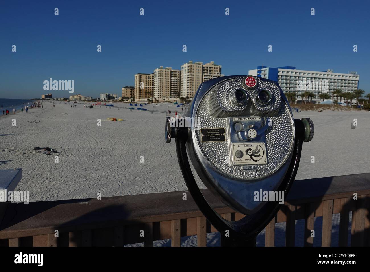 Osservatore binoculare a gettoni affacciato sulla spiaggia di sabbia bianca da una passerella a Clearwater, Florida Foto Stock