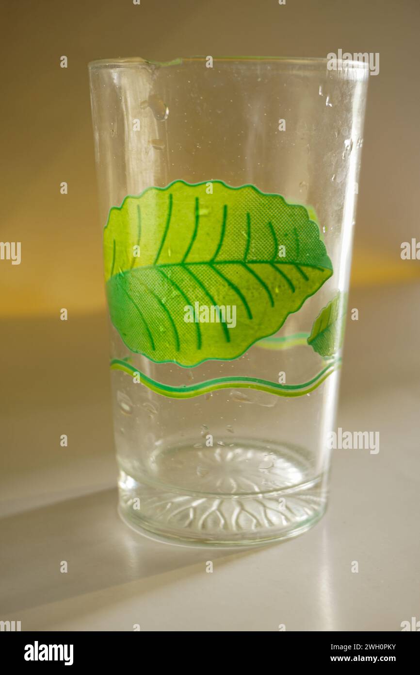Una tazza di vetro con un motivo floreale verde con uno sfondo che la isola Foto Stock
