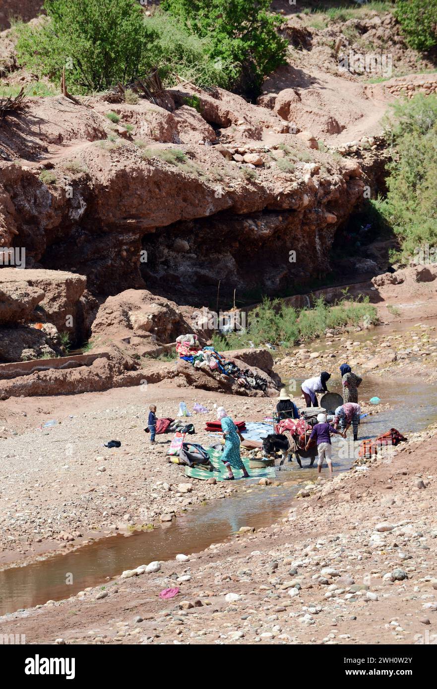 Donne berbere locali che lavano vestiti presso il fiume Asif Ounila da Ksar di Ait-Ben-Haddou in Marocco. Foto Stock