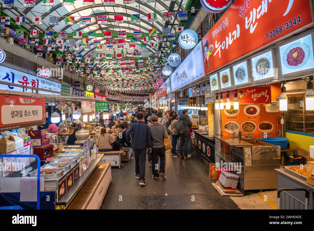 Seoul, Corea del Sud - 11 novembre 2022: Bancarelle di negozi e Street food con molti turisti al mercato di Gwangjang Foto Stock