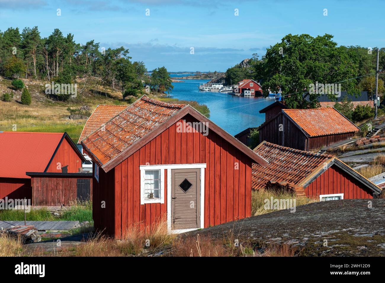 Estate in Svezia. Tradizionali capanne da pesca rosso falu ad Harstena, un'isola sulla costa orientale della Svezia nel Mar Baltico Foto Stock