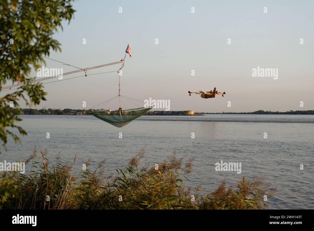 Canadair del vigile del fuoco in volo, riempito d'acqua, sul fiume Dordogna in Gironde Foto Stock