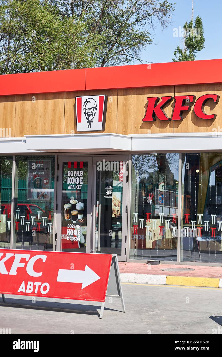 Ingresso al ristorante KFC, logo del colonnello Sanders. Catena internazionale di ristoranti di catering Kentucky Fried Chicken. Cielo blu estate. pubblicità all'aperto Foto Stock