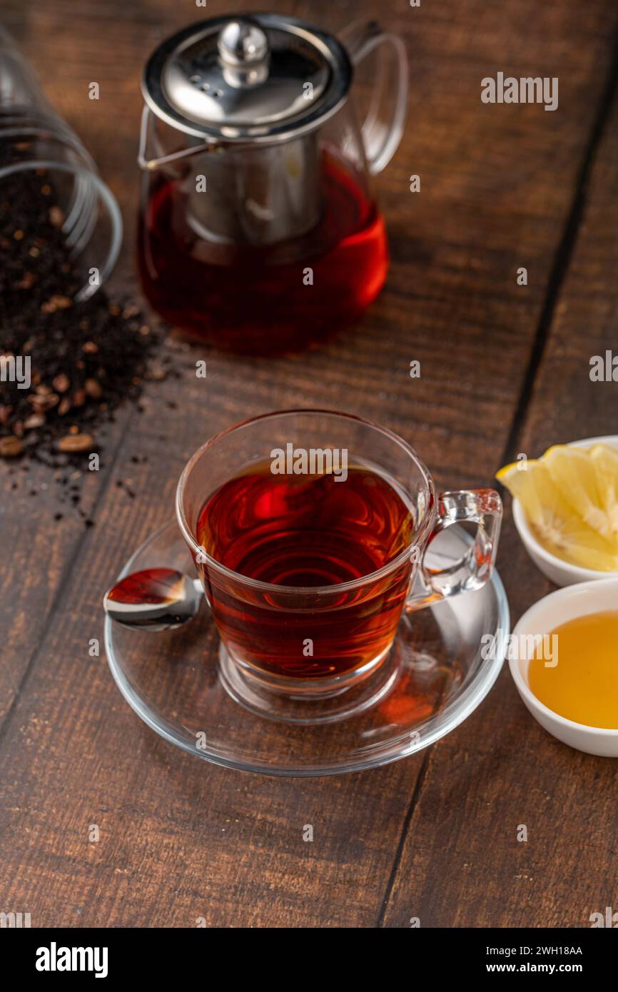 Vista dall'alto del tradizionale tè turco nero con limone e miele su sfondo in legno Foto Stock