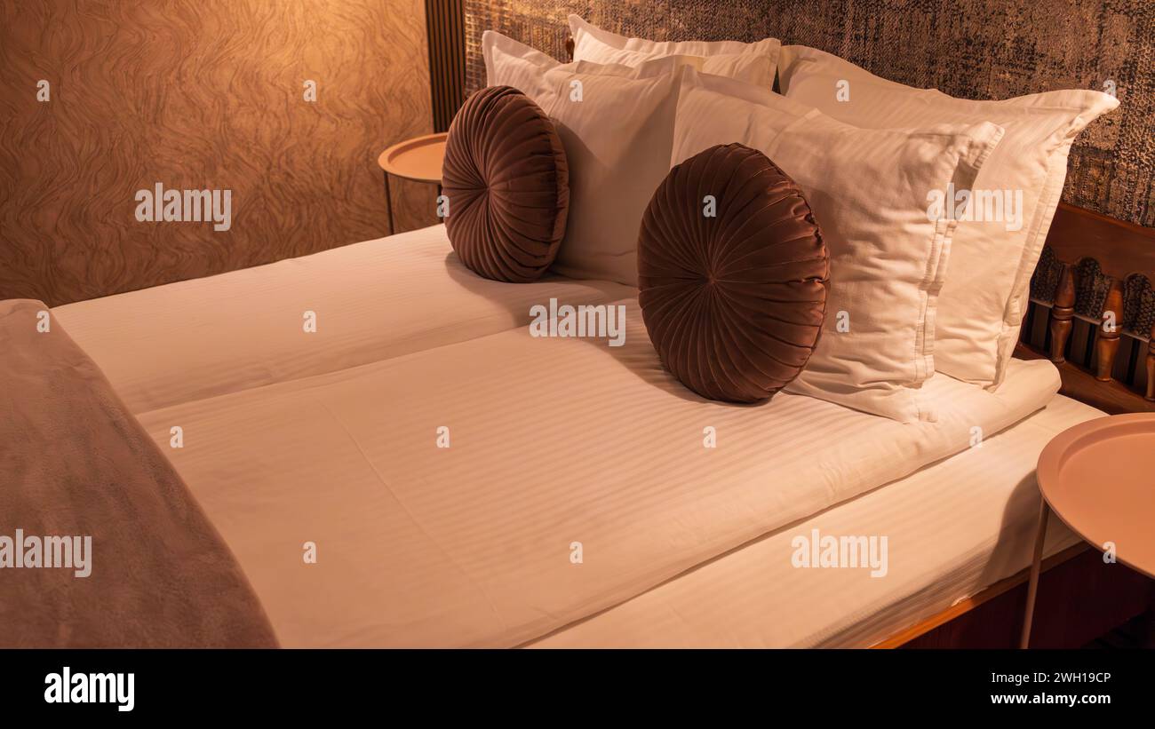 Due cuscini disposti in modo ordinato fianco a fianco su un comodo letto in una camera d'hotel Foto Stock