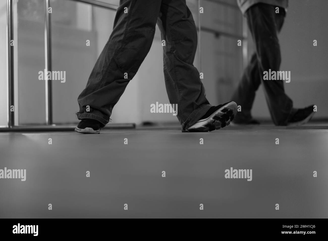 Sezione bassa di breakdancer gambe che ballano in studio. Toni bianchi e vuoti Foto Stock