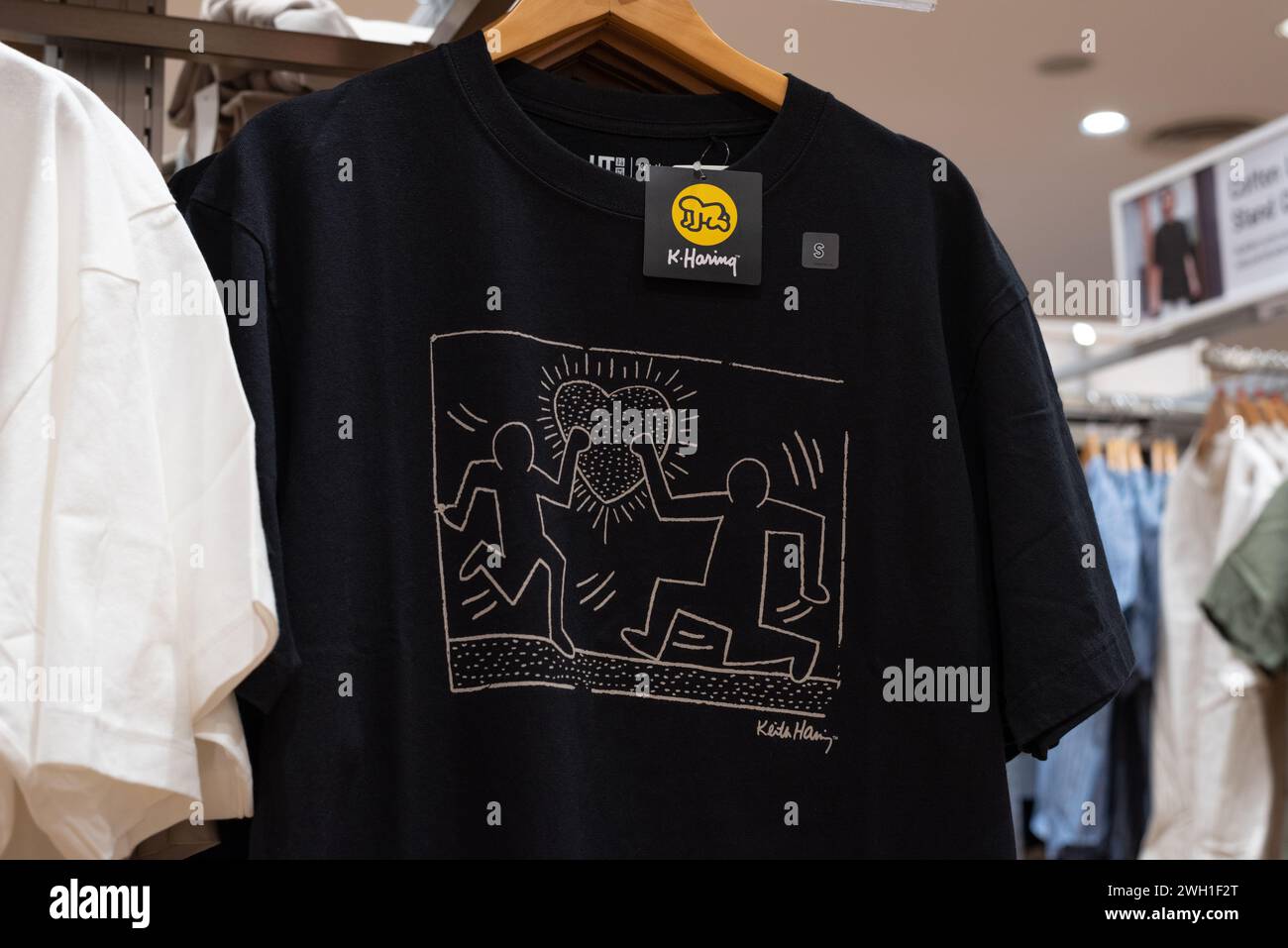 T-shirt Uniqlo nera con una stampa di Keith Haring disegnata il 1° febbraio 2024 a Bangkok, Thailandia. Foto Stock