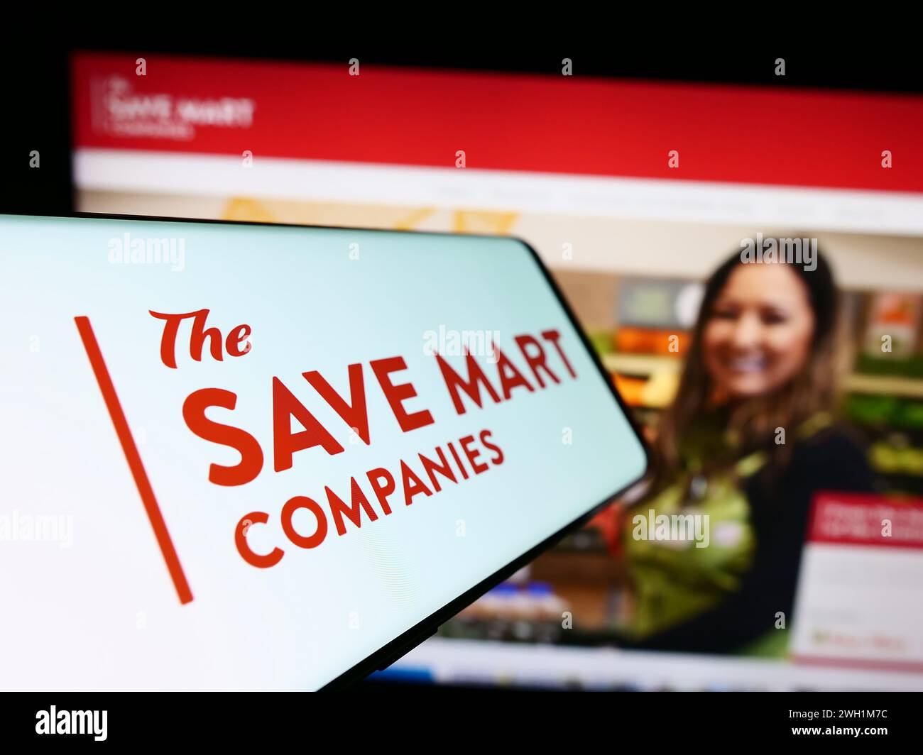 Smartphone con logo della società americana di supermercati The Save Mart Companies davanti al sito Web. Mettere a fuoco la parte centrale sinistra del display del telefono. Foto Stock