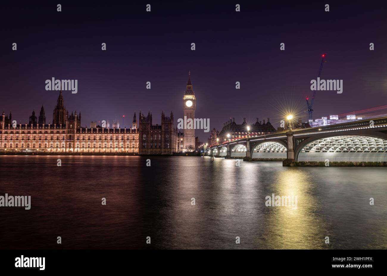 Londra. REGNO UNITO- 02.04.2024. Una vista notturna a lunga esposizione del Palazzo di Westminster, del Big Ben e del Ponte di Westminster che proiettano riflessi di luce sul Foto Stock