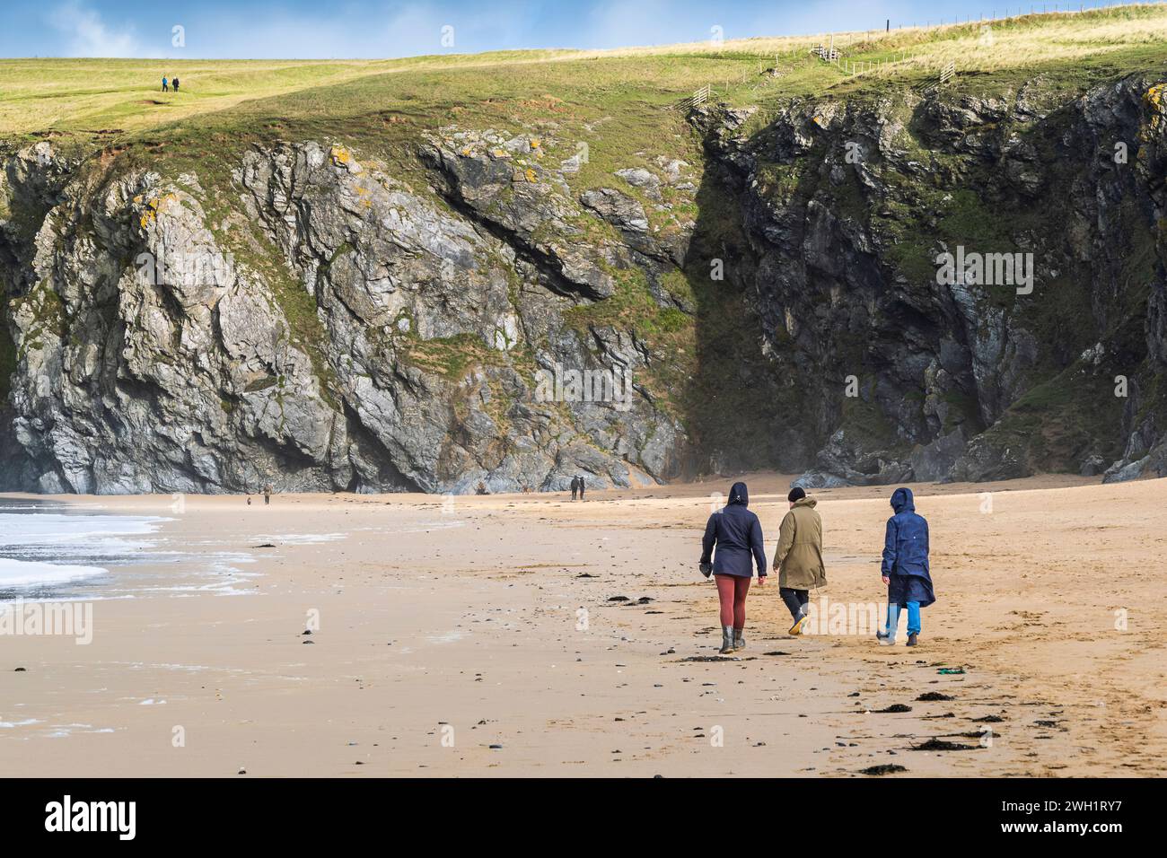 Persone che si godono una passeggiata lungo Holywell Beach a Newquay, in Cornovaglia, nel Regno Unito. Foto Stock