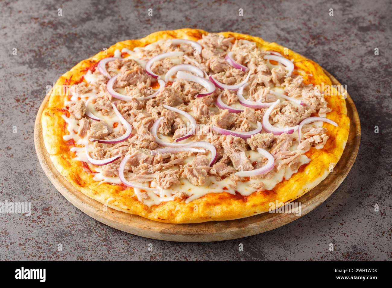 Pizza di pesce con salsa di pomodoro, tonno in scatola, mozzarella e cipolla rossa primo piano su un tavolo di legno sul tavolo. Orizzontale Foto Stock