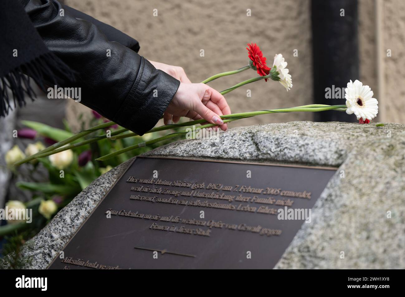 Berlino, Germania. 7 febbraio 2024. Due donne posero dei fiori sulla pietra commemorativa di Hatun Aynur Sürücü durante un servizio commemorativo nel 19° anniversario della sua morte a Berlino. Fu uccisa dal fratello minore in strada, in una fermata dell'autobus, il 7 febbraio 2005, perché si credeva che il suo stile di vita avesse offeso l'onore della famiglia. Crediti: Sebastian Christoph Gollnow/dpa/Alamy Live News Foto Stock