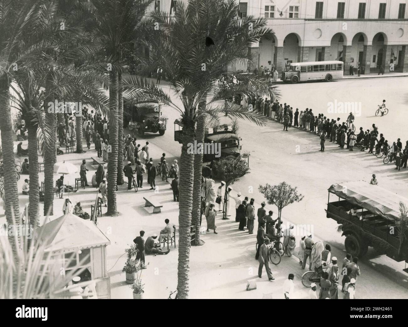 La seconda migrazione dei coloni rurali italiani in Libia: Colonne di camion che trasportano persone rurali alle fattorie di Gebel Cyrenaico nelle strade di Tripoli, Libia 1938 Foto Stock