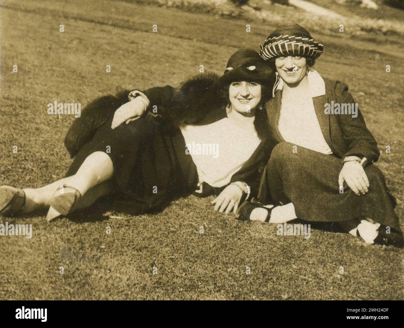 Due donne con cappello siedono sul prato, Italia anni '1920 Foto Stock