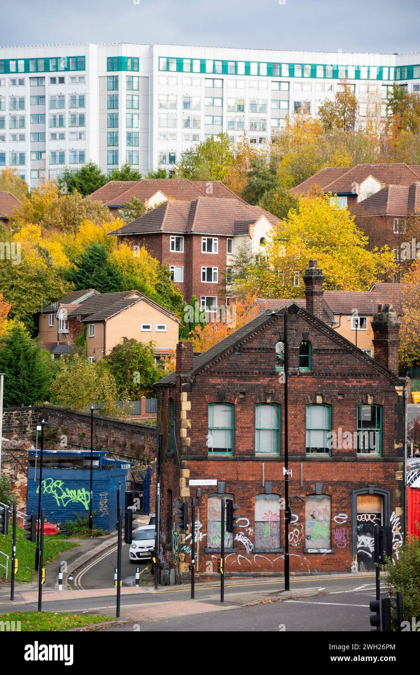 Sheffield, Regno Unito – 13 novembre 2021: Il derelict si è imbarcato sul Best Fit Tyre Centre con nuove case e appartamenti alle spalle, il paesaggio urbano di Sheffield vecchio e nuovo Foto Stock