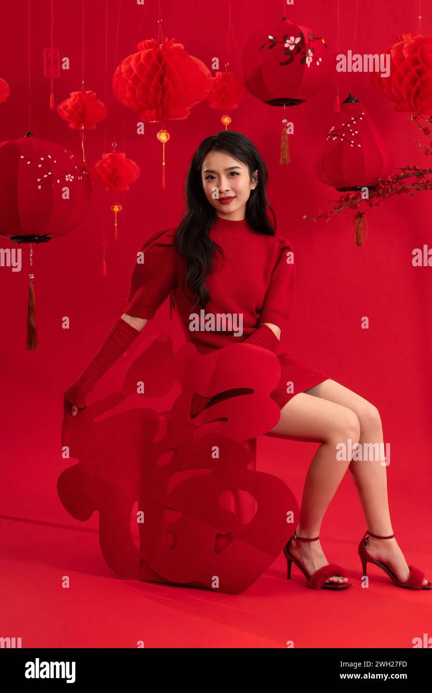 Atmosfera di Capodanno, una giovane donna asiatica su sfondo rosso Foto Stock