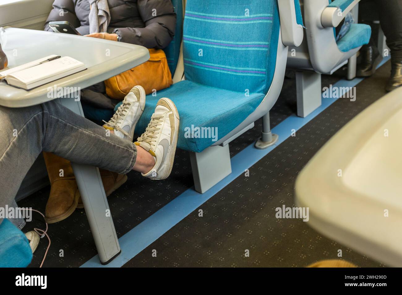 Piede passeggero femminile sul sedile del treno, Regno Unito Foto Stock