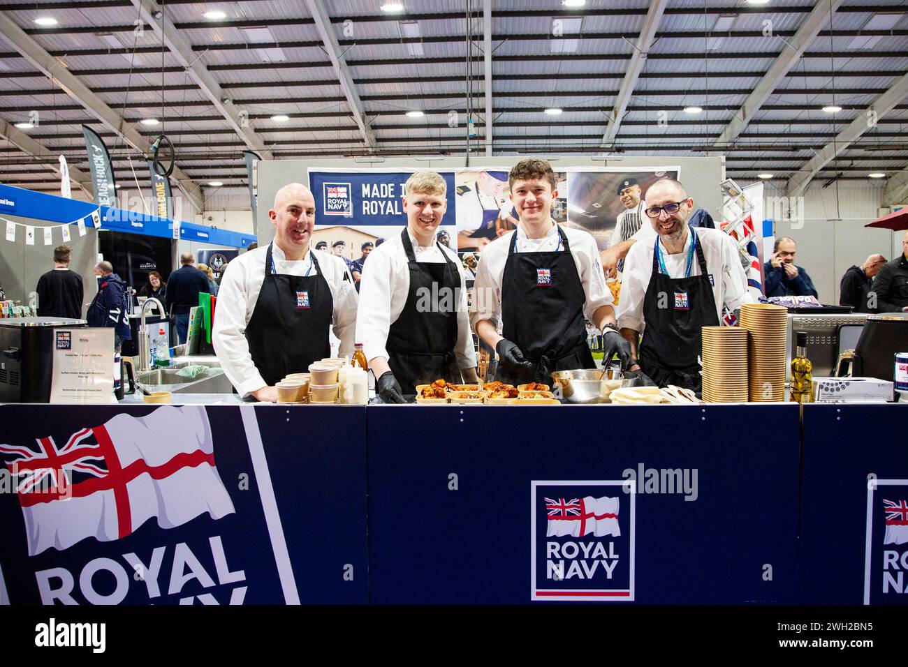 Gli chef della Royal Navy cucinano dal vivo alla fiera Source Food, drink, catering e ospitalità che si tiene a Westpoint Exeter Regno Unito, con espositori e marchi il 7 febbraio 2024 Foto Stock