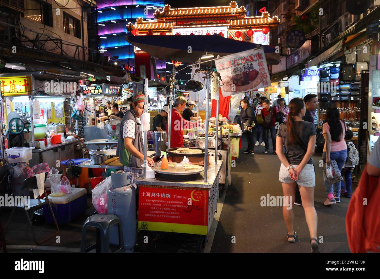 TAIPEI, TAIWAN - 4 DICEMBRE 2018: Il venditore cucina cibo di strada al mercato notturno di Raohe a Taipei. I mercati di cibo notturno sono una parte importante della cultura taiwanese. Foto Stock