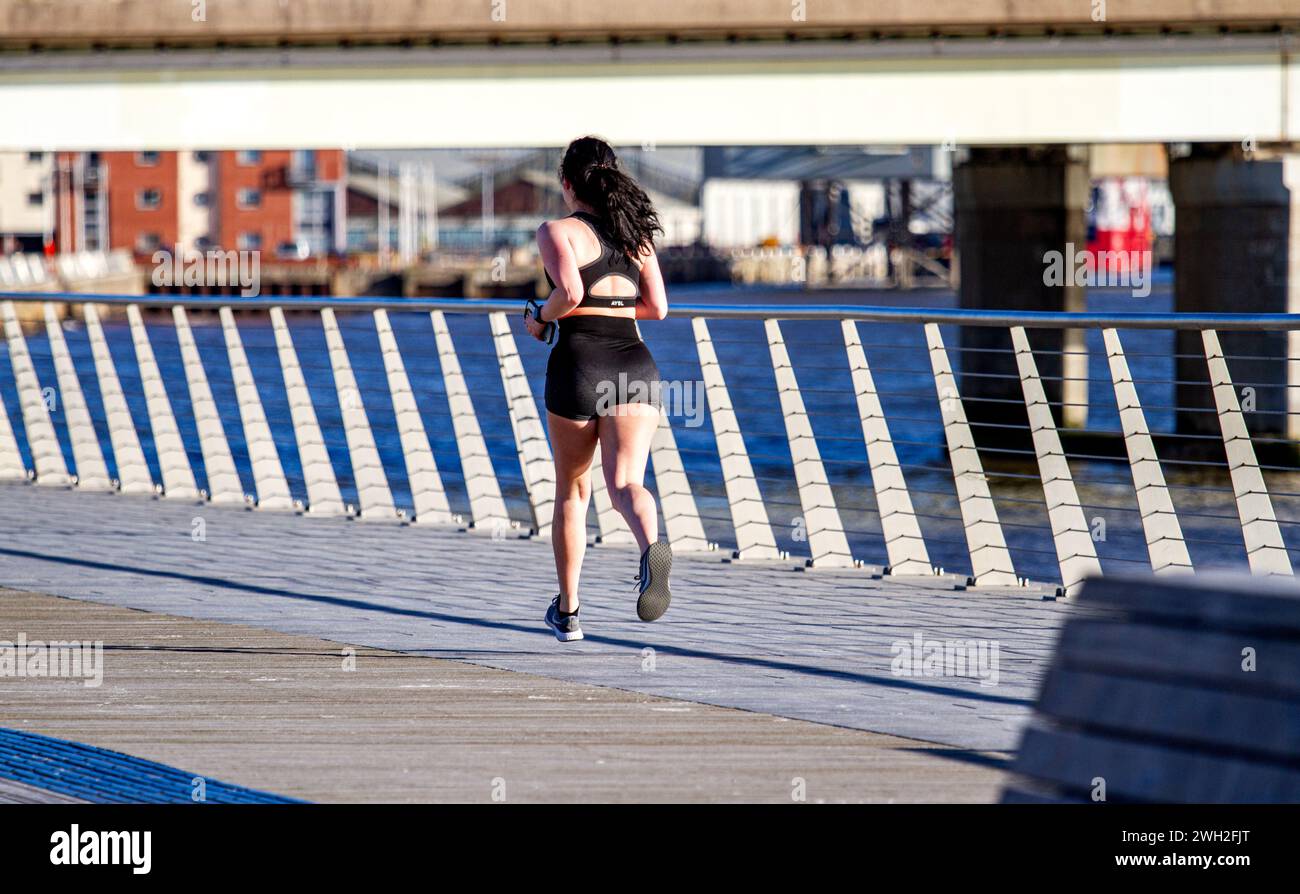 Dundee, Tayside, Scozia, Regno Unito. 7 febbraio 2024. Meteo nel Regno Unito: Tayside sta attualmente vivendo il freddo sole invernale, con temperature che raggiungono gli 8°C.. Questa mattina, una giovane jogger è fuori a godersi il sole di febbraio che corre lungo il lungomare di Dundee. Crediti: Dundee Photographics/Alamy Live News Foto Stock