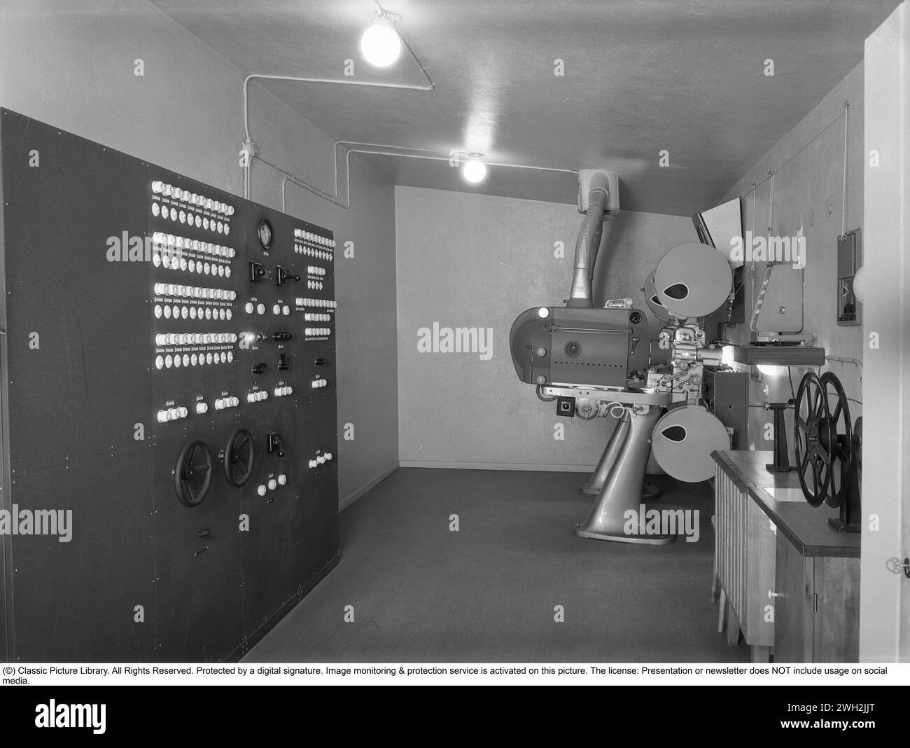 Dietro le quinte del cinema. Il cinema negli anni '1950 La sala proiettore di un cinema di Stoccolma. Vengono utilizzati due proiettori a pellicola. Dal momento che i film non si adattavano a un rotolo di pellicola, era importante che il macchinista fosse abile nel passare al proiettore successivo con il rotolo successivo al momento opportuno. L'operatore del cinema gestisce anche l'illuminazione nella sala cinematografica. Un pannello di controllo a sinistra controlla la luce nella sala cinematografica, le luci di scena, ecc. e anche la tenda. anni '1950 Foto Stock