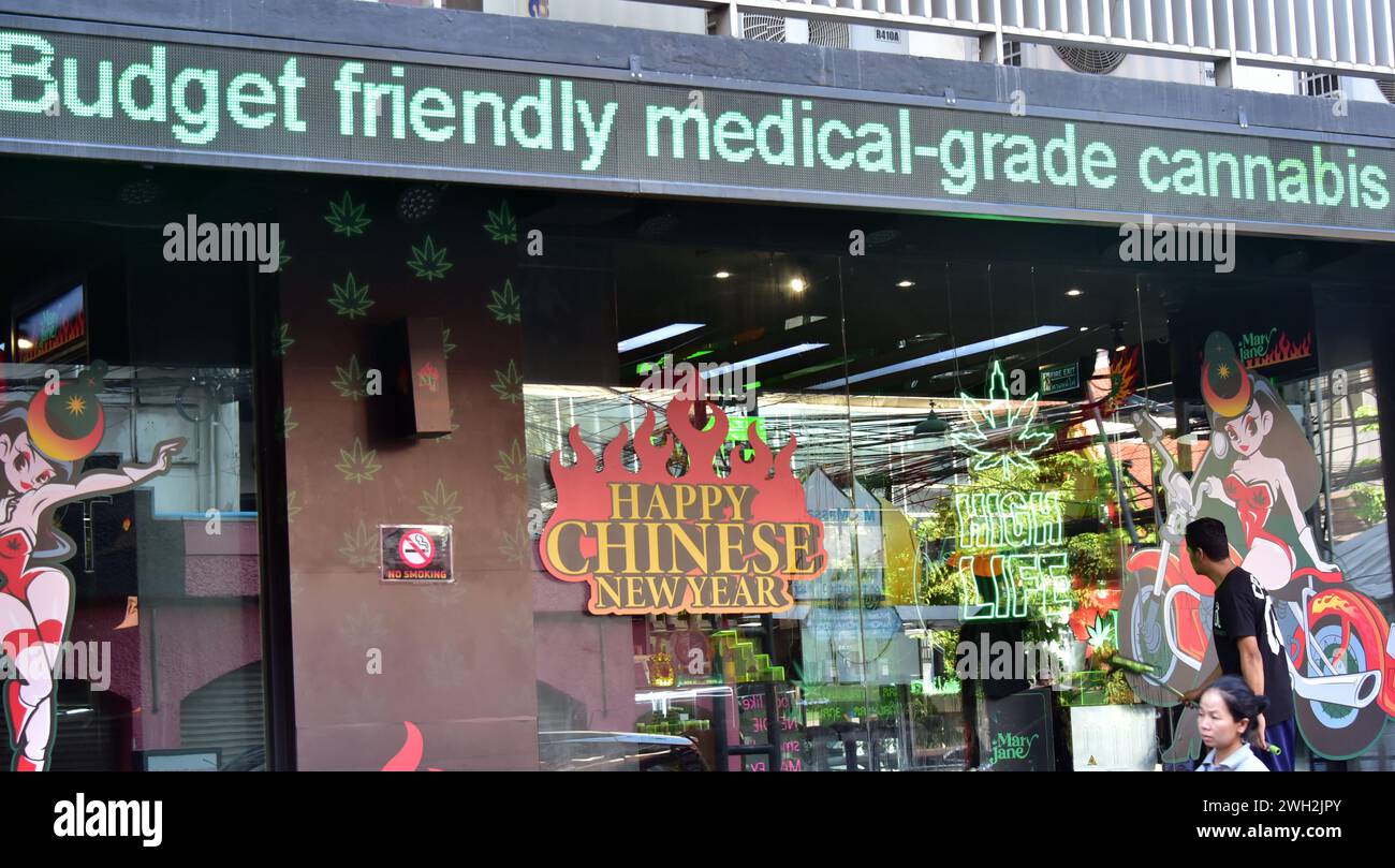 Un uomo pulisce la finestra di un negozio di cannabis su Surawong Road, Bangkok, Thailandia, Asia il 7 febbraio 2024. Il governo thailandese sta per proporre con urgenza una legge che vieti l'uso ricreativo di cannabis dopo la depenalizzazione nel 2022. La Cannabis rimossa dalla lista dei narcotici vietati nel giugno 2022, portando ad un aumento dei dispensari, specialmente a Bangkok. Il ministro della salute ha annunciato il nuovo disegno di legge nel febbraio 2024, che limita l'uso di cannabis a scopi sanitari e medicinali. Questo disegno di legge sarà presentato al Gabinetto la prossima settimana. Shop Sign offre: "Cannabis medica economica". Foto Stock