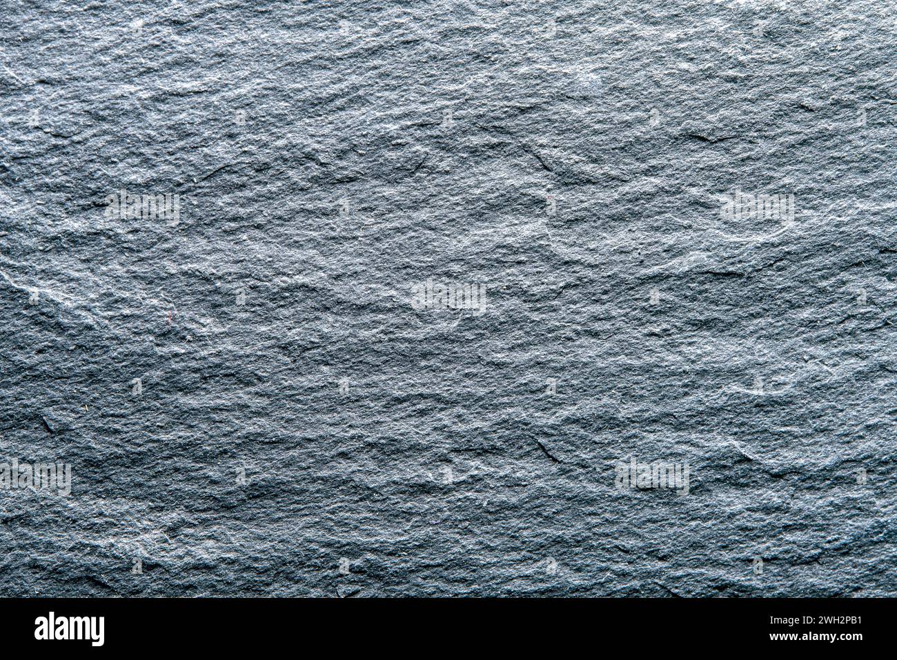 Struttura del piatto di ardesia grigio scuro come sfondo. Foto Stock