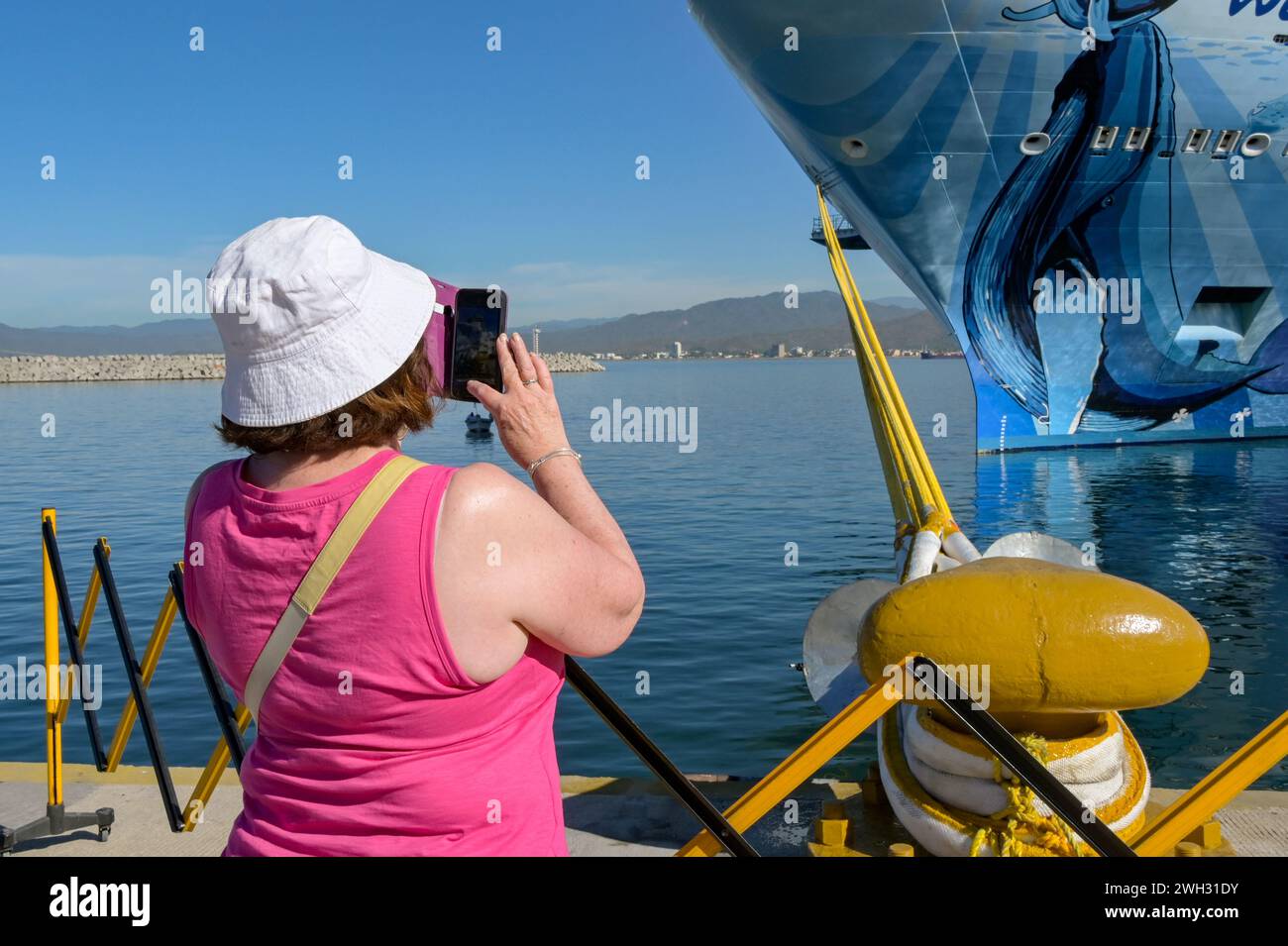 Manzanillo, Messico - 16 gennaio 2024: Il passeggero della nave da crociera scatta una foto del transatlantico norvegese Bliss su un telefono cellulare Foto Stock