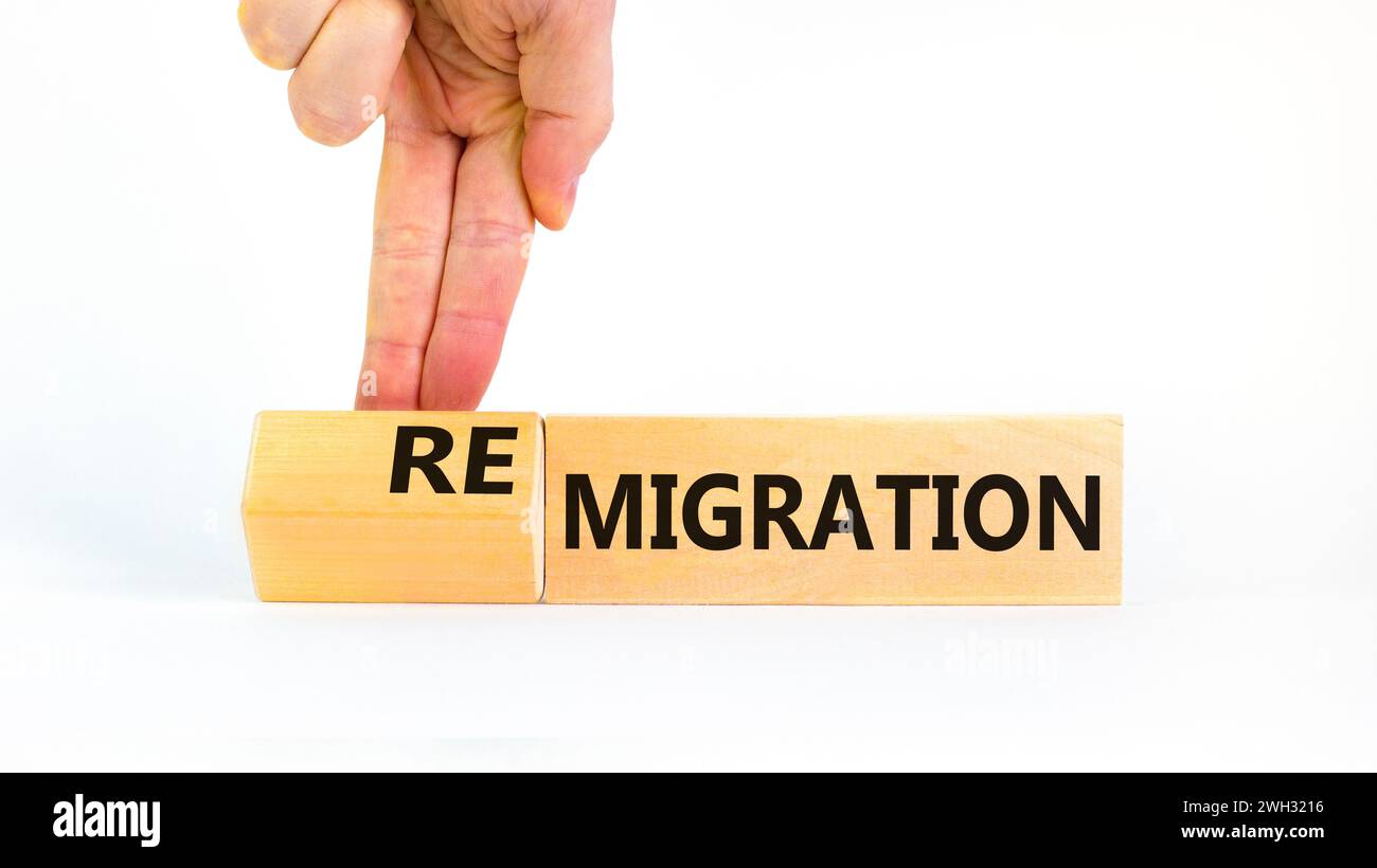 Simbolo di migrazione o di remigrazione. Concetto di Migration Remigration su bellissimi cubi di legno. Splendido sfondo bianco. Mano d'affari. Affari Foto Stock