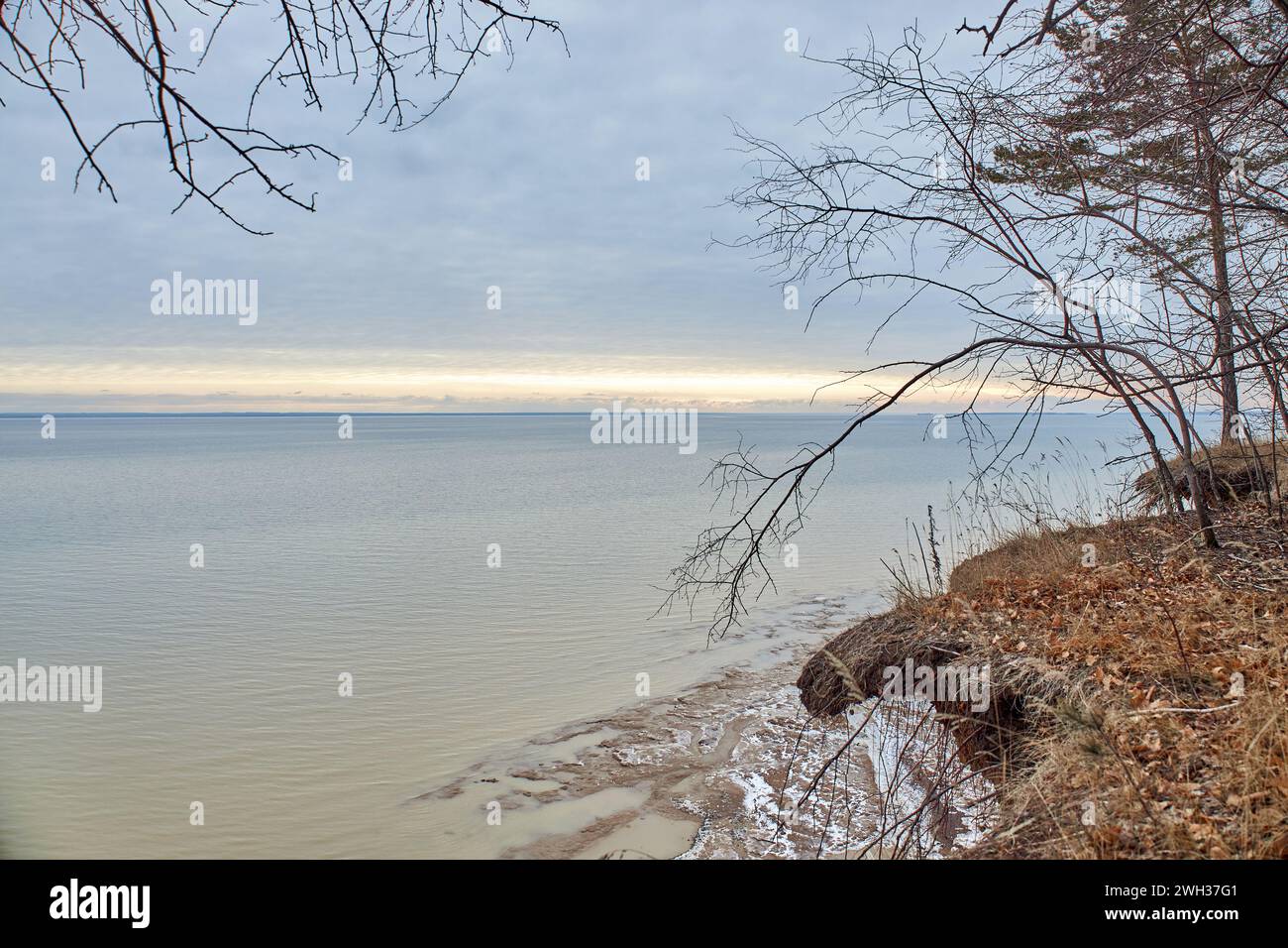 Bacino idrico di Novosibirsk, OB Sea, stagno artificiale sulla riva del fiume OB. Tramonto sul mare con nuvole blu e una striscia di luce gialla brillante. Cielo di aprile primaverile Foto Stock