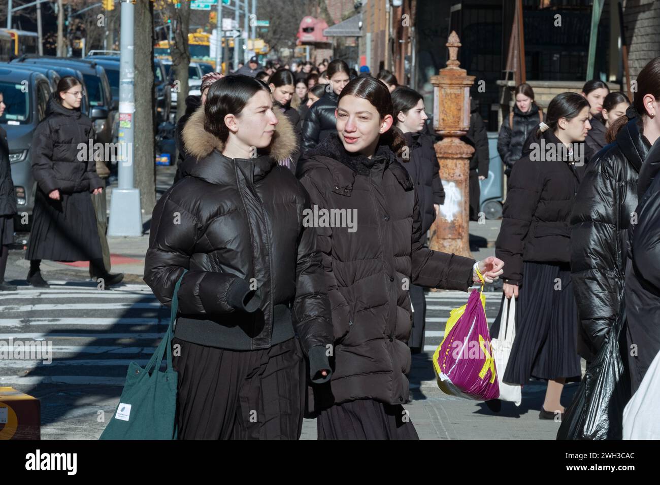 Le ragazze ebree ortodosse, vestite modestamente, vanno a scuola la domenica mattina d'inverno Foto Stock