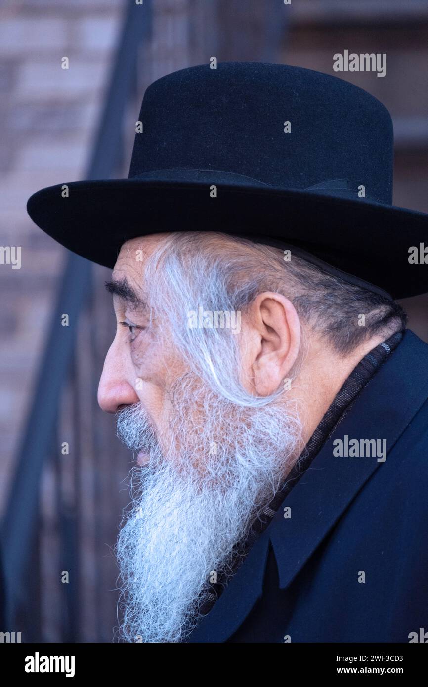 Una foto profiie di un ebreo ortodosso anziano con un lungo peyus. In una strada a Brooklyn, New York. Foto Stock