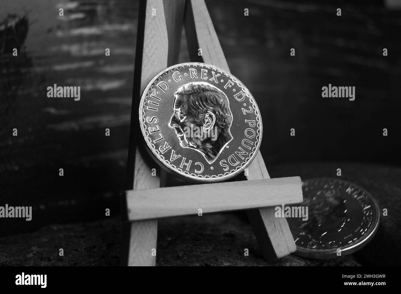 Moneta d'argento puro del Regno Unito su cavalletto. 2 libbre Charles III. Foto in bianco e nero. Foto Stock