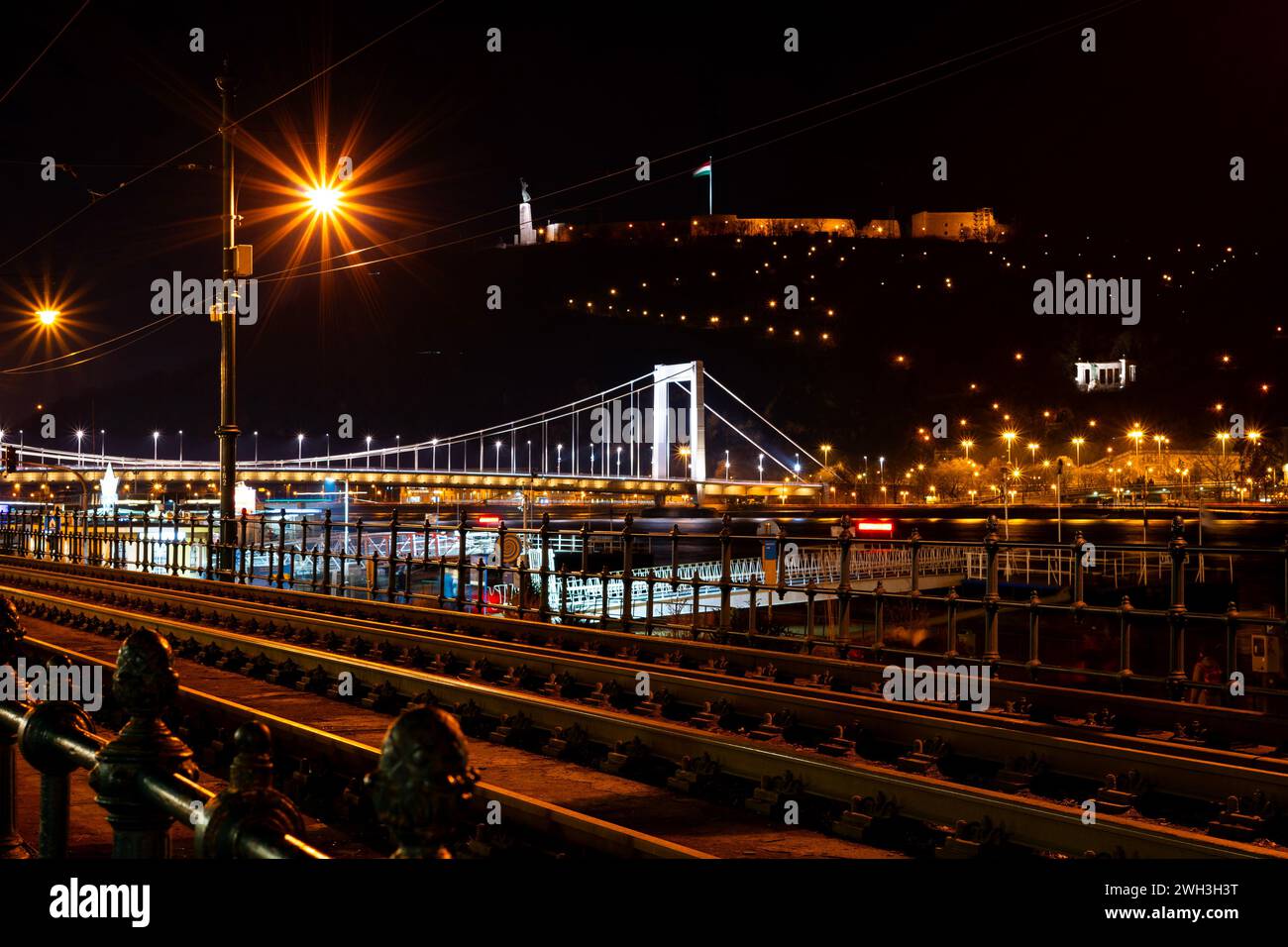 Ponte Elisabetta illuminato con luci notturne sul Danubio. Con tram in primo piano e Gellért Hill sullo sfondo. Budapest, Ungheria Foto Stock